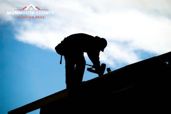 Silhouette of a roofer repairing a roof in Marlboro Township, NJ.